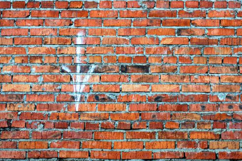 old brick wall, white arrow down.